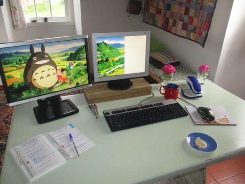mesa de trabajo con dos monitores y dos rosas